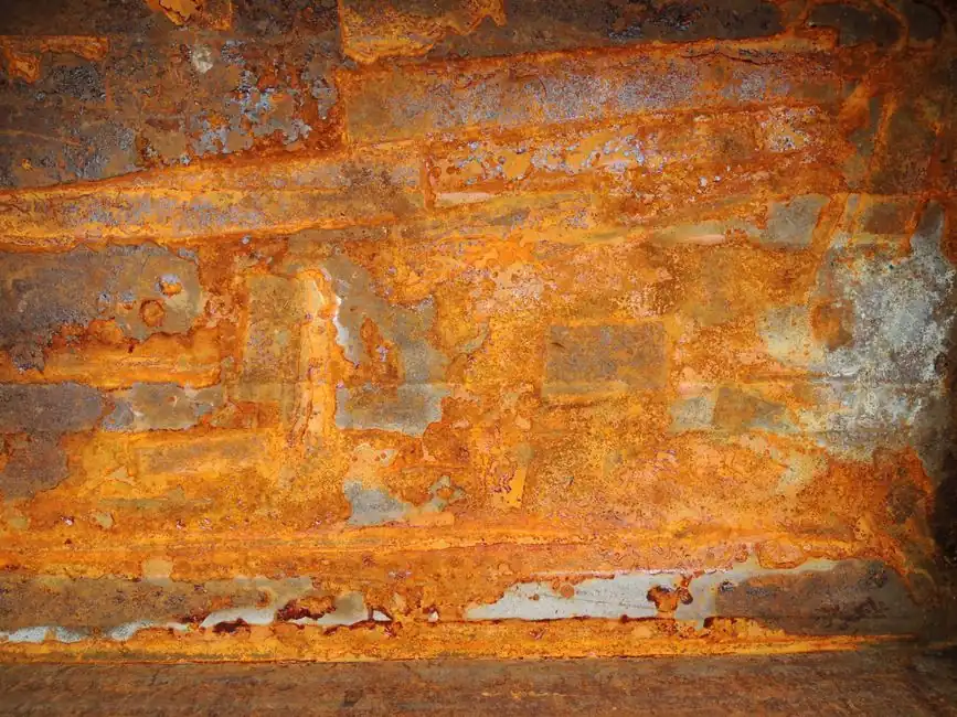 Detailed close-up of a rusty metal wall showing textures and patterns.